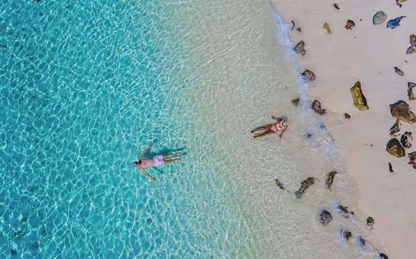 白い熱帯のビーチとターコイズブルーの海を持つコクラダン島の海で2人のカップルが泳いでいます 無人機で上から見た青い海の男と女 — ストック写真