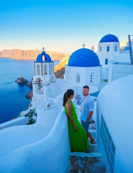 在希腊桑托里尼 男人和女人在夏日的日出时分参观了粉刷过的希腊村庄Oia 那里的蓝色圆顶和白色的教堂 — 图库照片