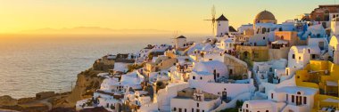 White churches and blue domes by the ocean of Oia Santorini Greece, a traditional Greek village in Santorini in the evening light clipart