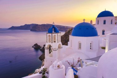 White churches an blue domes by the ocean of Oia Santorini Greece, a traditional Greek village in Santorini.