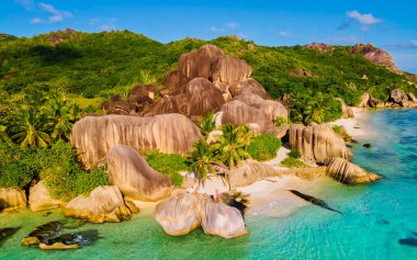 Anse Source dArgent beach, La Digue Island, Seyshelles, Drone aerial view of La Digue Seychelles bird eye view.of tropical Island, couple men and woman walking at the beach during sunset at a luxury