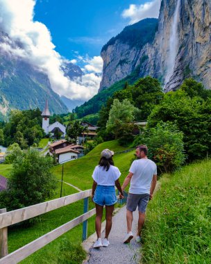 Yazın Lauterbrunnen Vadisi 'nde muhteşem bir şelale ve İsviçre Alpleri' ni ziyaret eden erkek ve kadınlar, Berner Oberland, İsviçre, Avrupa