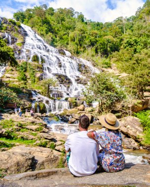 Çift Mae Ya Waterfall Doi Inthanon Ulusal Parkı Tayland Chiang Mai 'yi ziyaret ediyor. Asyalı kadınlar ve beyaz erkekler şelaleyi ziyaret ediyor