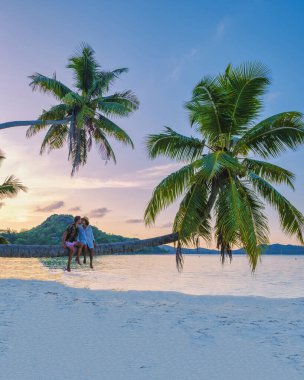 Praslin Seychelles tropikal adası. Withe plajları ve palmiye ağaçları olan bir çift adam ve Anse Volber Seyşeller 'de palmiye ağacı olan bir kadın. günbatımı palmiyesi