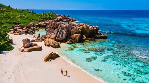 セーシェルでの豪華な休暇中に熱帯のビーチで若い男女のカップルであるAnse Cocos Digue Seashele トロピカルビーチ Anse Cocos Digue Seasel — ストック写真