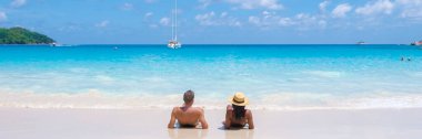 Anse Lazio Praslin Seyşeller, tropik bir plajda lüks bir tatil yapan genç bir çift. Tropik plaj Anse Lazio Praslin Seyşeller Adaları