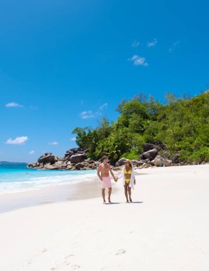 Anse Lazio Praslin Seyşeller, tropik bir plajda lüks bir tatil yapan genç bir çift. Tropik plaj Anse Lazio Praslin Seyşeller tropikal adaları