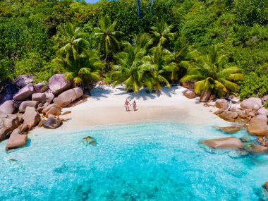 Anse Lazio Praslin Seyşeller, tropik bir plajda lüks bir tatil sırasında genç bir çift kadın ve erkek. Tropik plaj Anse Lazio Praslin Seyşeller Adaları güneşli bir günde mavi gökyüzü