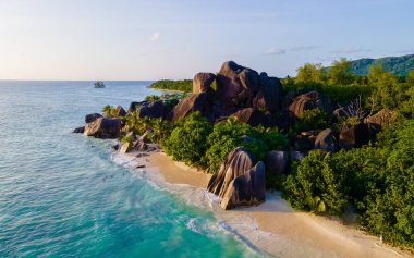 Anse Source dArgent, La Digue Seychelles, Seyşeller 'de lüks bir tatil sırasında tropikal bir plajda yaşayan genç bir çift. Anse Kaynak dArgent, La Digue Seyşeller