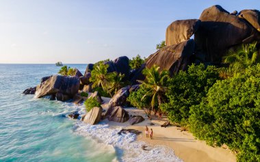 Anse Source dArgent, La Digue Seychelles, Seyşeller 'de lüks bir tatil sırasında tropikal bir plajda birkaç kadın ve erkek. Tropik sahil Anse Kaynak dArgent, La Digue Seyşeller