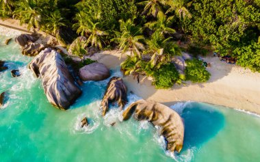 Anse Source dArgent, La Digue Seychelles, Seyşeller 'de lüks bir tatil sırasında tropikal bir plajda birkaç kadın ve erkek. Tropik sahil Anse Kaynak dArgent, La Digue Seyşeller