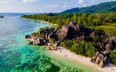 Anse Source dArgent, La Digue Seychelles, Seyşeller 'de lüks bir tatil sırasında tropikal bir plajda yaşayan genç bir çift. Tropik sahil Anse Kaynak dArgent, La Digue Seyşeller