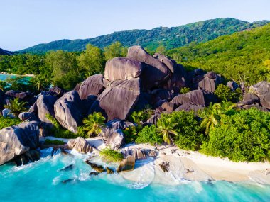 Anse Source dArgent, La Digue Seychelles, Seyşeller 'de lüks bir tatil sırasında tropikal bir plajda birkaç kadın ve erkek. Tropik sahil Anse Kaynak dArgent, La Digue Seyşeller