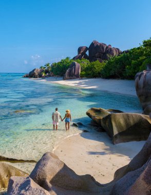 Anse Source dArgent, La Digue Seychelles, Seyşeller 'de lüks bir tatil sırasında tropikal bir plajda yaşayan genç bir çift. Anse Kaynak dArgent, La Digue Seyşeller