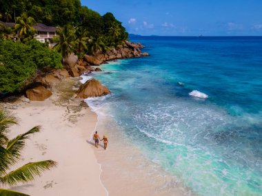Anse Patates, La Digue Seychelles, Seyşeller 'de lüks bir tatil sırasında tropik bir plajda yaşayan genç bir çift. Tropik sahil Anse Patates, La Digue Seyşeller