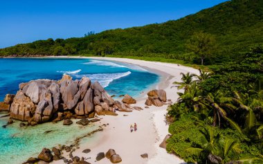 Anse Cocos La Digue Seyşeller, Seyşeller 'de lüks bir tatil sırasında tropik bir plajda yaşayan genç bir çift. Tropik sahil Anse Cocos La Digue Seyşeller mavi okyanuslu