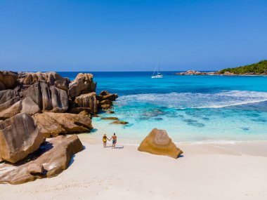 Erkek ve kadın Anse Cocos La Digue Seyşeller plajında, Seyşeller 'de lüks bir tatil sırasında tropik bir plajda yaşayan genç bir çift. Tropik sahil Anse Cocos La Digue Seyşeller. 