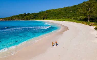 Anse Cocos La Digue Seyşeller, Seyşeller 'de lüks bir tatil sırasında tropik bir plajda birkaç kadın ve erkek. Tropik sahil Anse Cocos La Digue Seyşeller. 