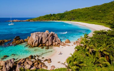 Erkek ve kadın Anse Cocos La Digue Seyşeller plajında, Seyşeller 'de lüks bir tatil sırasında tropik bir plajda yaşayan genç bir çift. Tropik sahil Anse Cocos La Digue Seyşeller. 