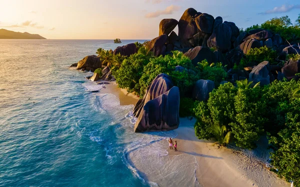 Anse Source dArgent, La Digue Seychelles, Seyşeller 'de lüks bir tatil sırasında tropikal bir plajda yaşayan genç bir çift. Tropik sahil Anse Kaynak dArgent, La Digue Seyşeller