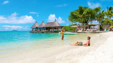 Mauritius 'ta tropikal bir plajda erkek ve kadın. Güneşli bir günde Mauritius' ta balayı tatilinde olan bir çift. Turkuaz renkli bir okyanus ve beyaz bir plaj.