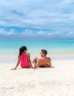 Mauritius 'ta tropik bir plajda erkek ve kadın, Mauritius' ta balayı tatili yapan bir çift, okyanus kenarında dinleniyor.