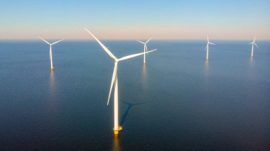 Bulutları ve mavi gökyüzü olan off-shore yel değirmeni parkı, rüzgar türbini Flevoland Hollanda 'nın deniz manzaralı yel değirmeni parkı Ijsselmeer. Hollanda 'da Yeşil Enerji