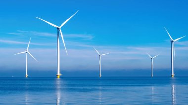 Bulutları ve mavi gökyüzü olan off-shore yel değirmeni parkı, rüzgar türbini Flevoland Hollanda 'nın deniz manzaralı yel değirmeni parkı Ijsselmeer. Hollanda 'da Yeşil Enerji