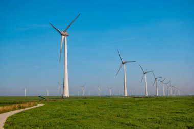 Bulutlu ve mavi gökyüzü olan yel değirmeni parkı, rüzgâr türbini Flevoland Hollanda 'nın deniz manzaralı yel değirmeni parkı. Yeşil enerji 