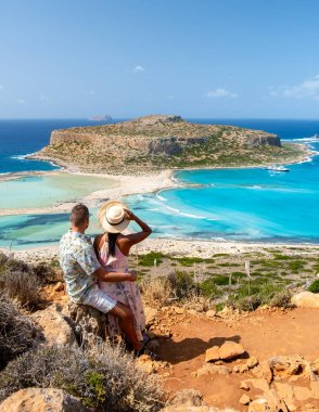 Girit Yunanistan, Balos lagünü Girit Adası, Yunanistan. Turistler Balos Sahili 'nin berrak okyanusunda dinleniyorlar. Güneşli bir günde Yunanistan 'da bir tatil sırasında iki erkek ve bir kadın plajı ziyaret ediyor.