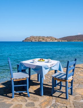 Girit Yunanistan Plaka Lassithi, geleneksel bir mavi masa ve Girit Yunanistan plajındaki sandalyeler. Paralia Plakas, Plaka Köyü Girit. 