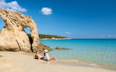 Voulisma Beach Istron Crete Greece, beautiful beaches of Crete island Istron Bay near Agios Nikolaos. A young couple on vacation in Greece Crete during the summer holidays clipart