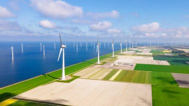 Bulutları ve mavi gökyüzü olan yel değirmeni parkı, rüzgar türbini Flevoland Hollanda Ijsselmeer ile okyanus drone hava manzaralı. Hollanda 'da Yeşil Enerji