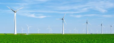 Bulutlu ve mavi gökyüzü olan yel değirmeni parkı, rüzgâr türbini Flevoland Hollanda 'nın deniz manzaralı yel değirmeni parkı. Hollanda 'da yeşil enerji üretimi