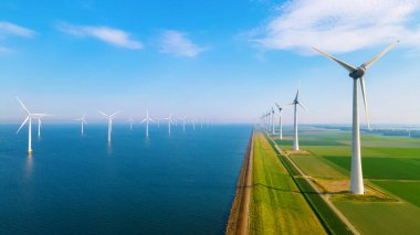 Bulutları ve mavi gökyüzü olan off-shore yel değirmeni parkı, rüzgar türbini Flevoland Hollanda 'nın deniz manzaralı yel değirmeni parkı Ijsselmeer. Hollanda 'da Yeşil Enerji