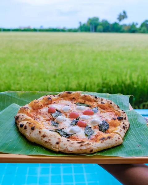 pizza at a farm stay in Thailand with green rice fields, homemade pizza.