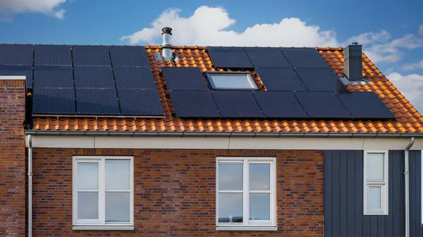 Nowo Wybudowane Domy Czarnymi Panelami Słonecznymi Dachu Przeciwko Słonecznemu Niebu — Zdjęcie stockowe