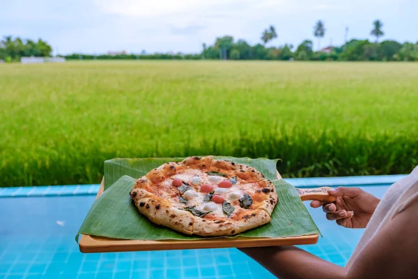 pizza at a farm stay in Thailand with green rice fields, homemade pizza.