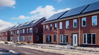 Çatıya güneş panelleri iliştirilmiş yeni evler, çatıda fotovoltaik paneller.
