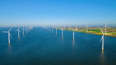 Bulutlu ve mavi gökyüzü olan yel değirmeni parkı, rüzgâr türbini Flevoland Hollanda 'nın deniz manzaralı yel değirmeni parkı. Hollanda 'da yeşil enerji üretimi