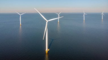 Rüzgâr değirmeni türbinleri bulutlu ve mavi gökyüzü olan parklar, rüzgâr türbini Flevoland Hollanda Ijsselmeer ile okyanus havası manzaralı yel değirmeni parkı. Hollanda 'da Yeşil Enerji üretimi