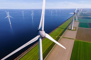Bulutlu ve mavi gökyüzü olan yel değirmeni parkı, rüzgar türbini Flevoland Hollanda Ijsselmeer ile okyanus havadan görülebilen rüzgar türbinleri. Hollanda 'da Yeşil Enerji üretimi