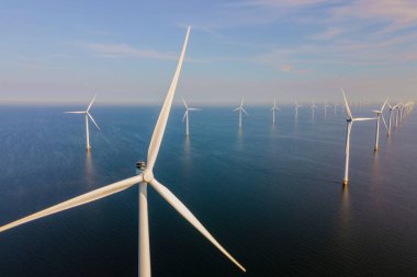 Bulutlu ve mavi gökyüzü olan yel değirmeni parkı, okyanusta rüzgar türbinleri, rüzgar türbini Flevoland Hollanda Ijsselmeer ile hava manzaralı.. 