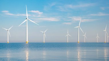 Flevoland Hollanda 'daki Ijsselmeer' de rüzgar türbinleriyle okyanus manzaralı yel değirmeni parkı. Hollanda 'da Yeşil Enerji üretimi