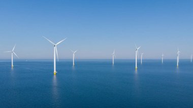 Okyanustaki yel değirmeni parkı, yeşil enerji üreten yel değirmeni türbinlerinin insansız hava görüntüsü, Hollanda 'da denizde izole edilmiş yel değirmenleri.