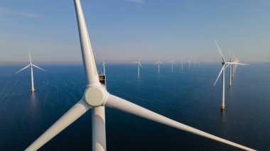 Okyanus açıklarındaki yel değirmeni çiftliği Westermeerwind Parkı 'nda, yel değirmenleri güzel, aydınlık bir günde Hollanda Flevoland Noordoostpolder' da izole edildi.