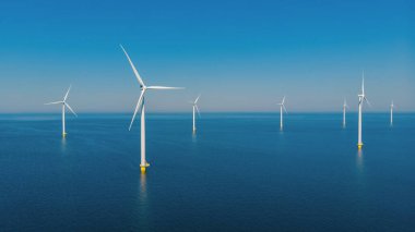 Kıyıdaki yel değirmeni parkında alternatif enerji. Hollanda 'da sabahları denizdeki yel değirmenleri