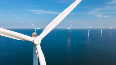 Okyanus açıklarındaki yel değirmeni çiftliği Westermeerwind Parkı 'ndaki yel değirmenleri Hollanda Flevoland Noordoostpolder' ın güneşli bir gününde denizde izole edilmiş.