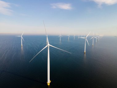 Okyanus açıklarındaki yel değirmeni çiftliği Westermeerwind Parkı 'ndaki yel değirmenleri Hollanda Flevoland Noordoostpolder' ın güneşli bir gününde denizde izole edilmiş.