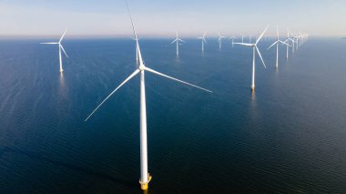 Bulutlu ve mavi gökyüzü olan yel değirmeni parkı, rüzgâr türbini Flevoland Hollanda 'nın deniz manzaralı yel değirmeni parkı. Hollanda 'da yeşil enerji üretimi